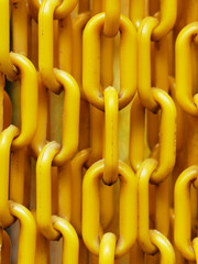 Yellow plastic chains hanged in front of the entrance of butterfly garden to prevent the butterfly from escaping show concepts of linkage, security, and strength
