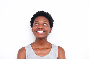 Close up young african woman looking up and smiling on white background
