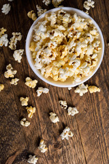  Prepared popcorn in frying pan, corn seeds in bowl and corncobs on kitchen table.Air salty popcorn. Salt popcorn on the wooden background . Chees .Popcorn texture