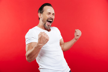 Excited happy adult man make winner gesture.