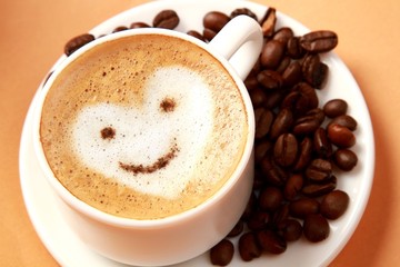 Cup of coffee surrounded by coffee beans