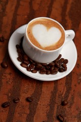 Cup of coffee surrounded by coffee beans