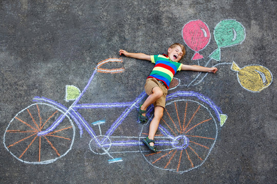 little kid boy having fun with bike chalks picture