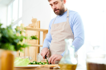 Mid section portrait of handsome mature man cooking salad and cutting vegetables in spacious kitchen at home, copy space