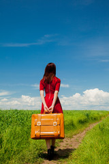 girl with suitcase at wheat field