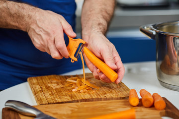 Man peeling carrots - Powered by Adobe