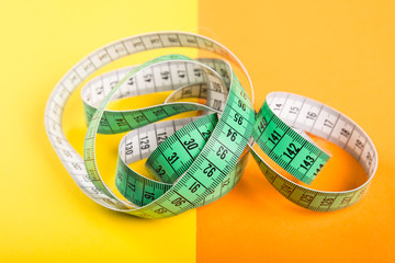 Measuring tape on yellow and orange background.