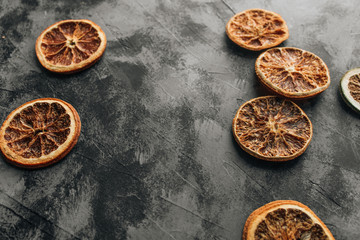 Slices of dry oranges on dark stone table