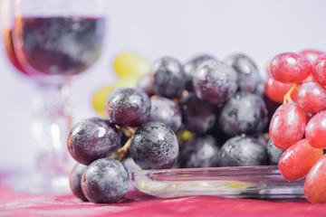 Fresh grape and red wine on the vintage table with two glasses, selective focus