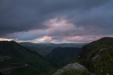 Naklejka na ściany i meble at dusk mountain road winds serpentine among the gorge in sunset