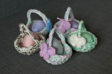 Obraz na płótnie Canvas Easter decoration, crochet mini basket, striped colorful egg wrapped in soft yarn thread, pastel colors, butterfly, wooden texture background. Homemade decor. Shallow depth of focus. Easter holidays.