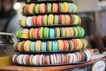 Colorful tasty french macarons in the street market background, close up. Bakery concept.Selective focus.