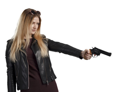 A girl in a leather jacket holds a revolver in her hands, danger, self-defense. The image of a confident and strong woman