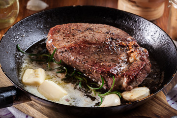 Preparing beef steak with cubed butter