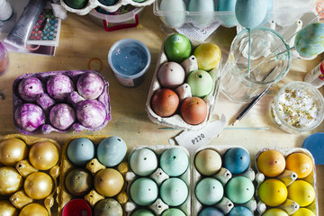 Messy table full of packages of Dyeing eggs for Easter holidays, colored  with different  tint eggs, top view, easter conceptual holiday photo.