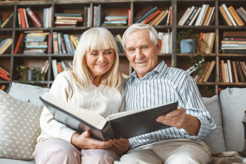 Senior couple together at home retirement concept photograph album front view