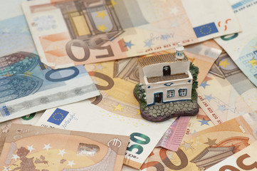 casa en miniatura sobre billetes de euro
