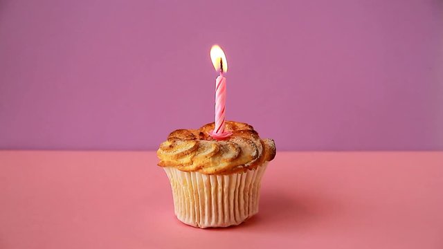 Cupcake with one lighted candle for the birthday