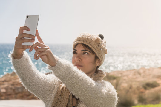 Ragazza si fa selfie al mare d'inverno