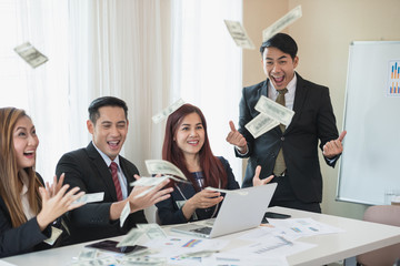 Asian business man and woman groups, successful business. There is a lot of money. with a laptop at office desk and document. business success concept