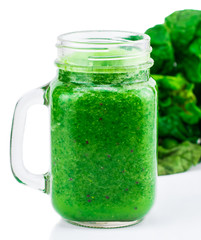 Healthy green smoothie with spinach in a jar mug isolated on white