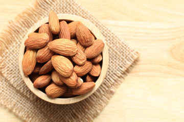 Almond in a bowl on wooden background with copy space