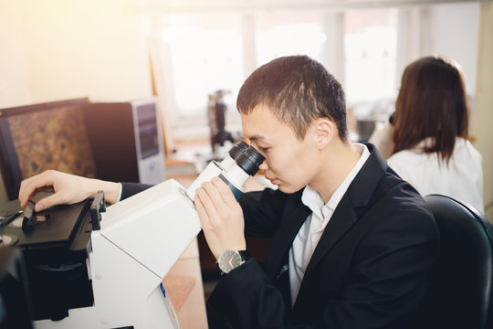 Materials Science. A young male student is sitting at a microscope.