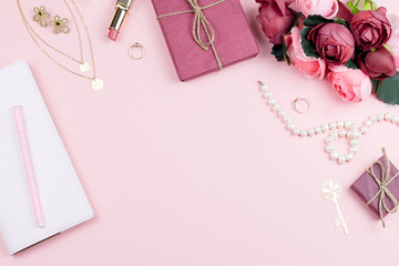 Woman fashion accessories, flowers, cosmetics and jewelry on pink background, copyspace.