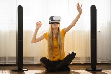 Girl wearing virtual reality goggles at home
