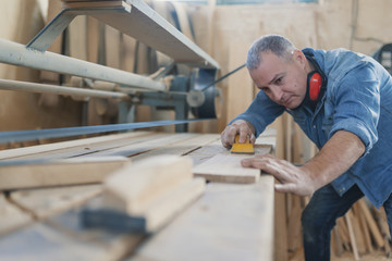 Attractive man doing woodwork in carpentry