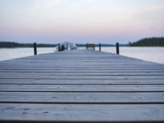 Obraz premium A closeup of a dock and a finnish lake scenery during summer. A boat at the background