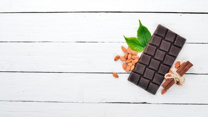 Dark chocolate with almond nuts. On a wooden background. Top view. Copy space for text.