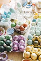Messy table full of packages of Dyeing eggs for Easter holidays, colored  with different  tint eggs, top view, easter conceptual holiday photo.