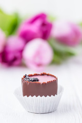 Hand made chocolate candiy and pink tulips on a white background. Free space