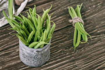 Fresh organic green beans in a metallic bowl on a rustic table
