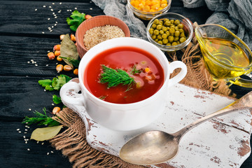 Tomato soup with chili and vegetables. Healthy food. On a black wooden background. Top view. Copy space for your text.
