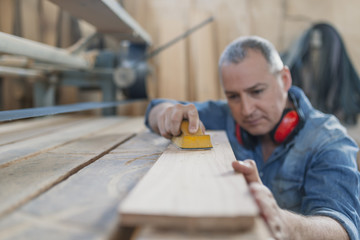 Portrait of handsome precise cabinetmaker during work in workshop