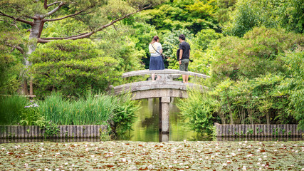 Rear view of couple over stone bridge