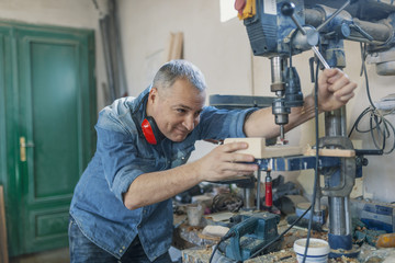 man engineer stand near saw machine to make furniture at carpenters workshop. Handmade business at small furniture factory. man working with  machine inside workshop