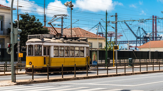 Strassenbahn in Lissabon vor Hängebrücke und Hafen
