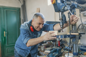 man engineer stand near saw machine to make furniture at carpenters workshop. Handmade business at small furniture factory. man working with  machine inside workshop