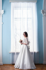 Fototapeta premium portrait of the bride on the window background