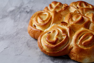 Homemade rose bread on white textured background, close-up, shallow depth of field, top view