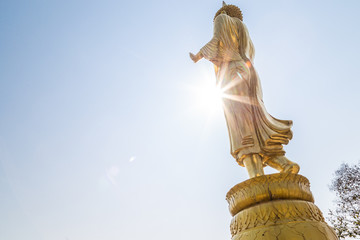 Golden buddha statue looking to city