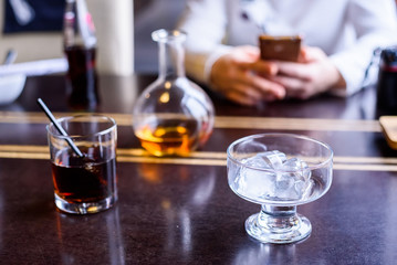 Glass of cola and ice cubes on restaurant table