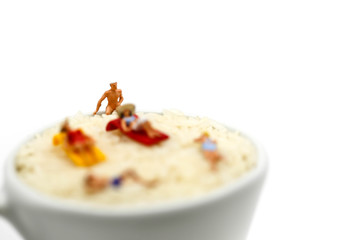 Miniature people : wearing swimsuit relaxing on white rice (Thai Jasmine rice).