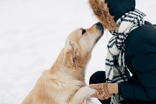 Image of dog giving paw to woman in black jacket on winter day