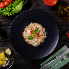 Spaghetti bolognese on black plate.