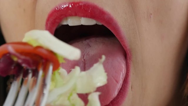 close-up of a young woman's mouth eating, slow motion