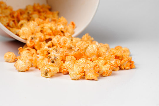 Macrophotograpy of fresh and warm tasty salt popcorn in a white paper bucket